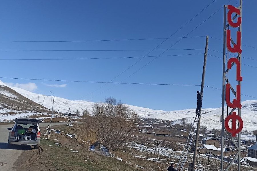 a person installing an antenna with a snowcapped landscape